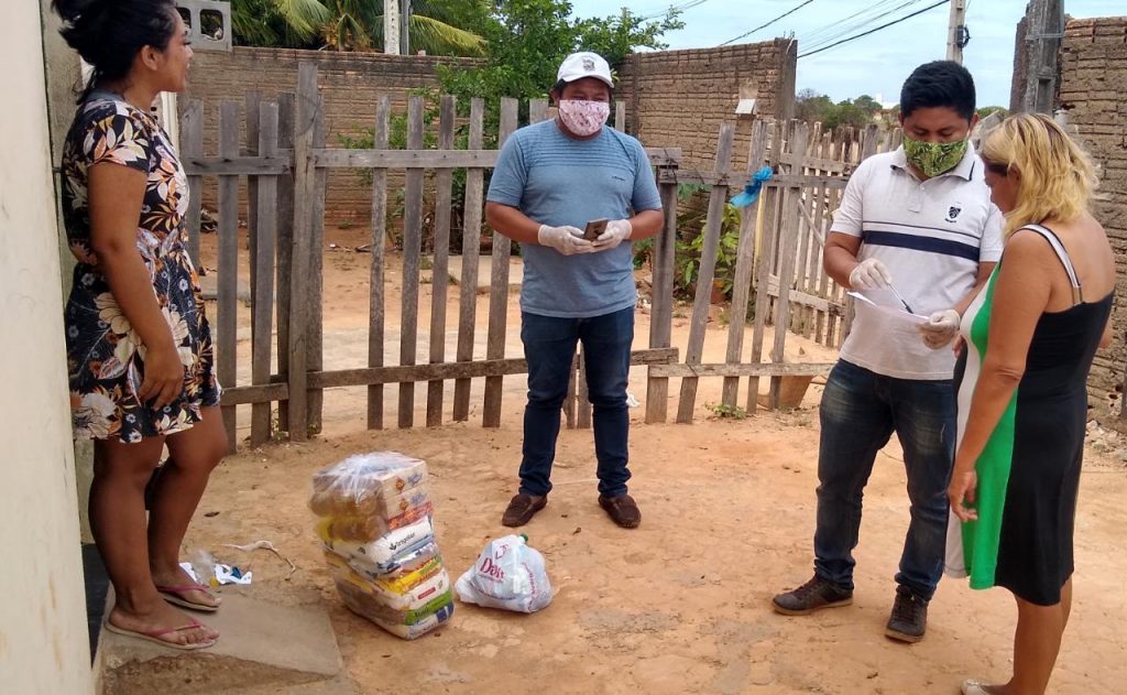 O vice-coordenador do CIR Edinho Batista e o assessor jurídico Junior Nicacio na entrega da cesta básica na residencia da dona Lucinda Santos Wapichana