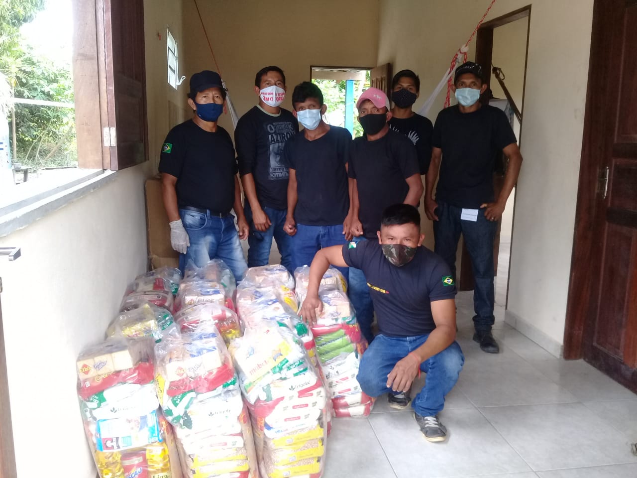 Seguranças da comunidade Malacacheta recebendo a doação.